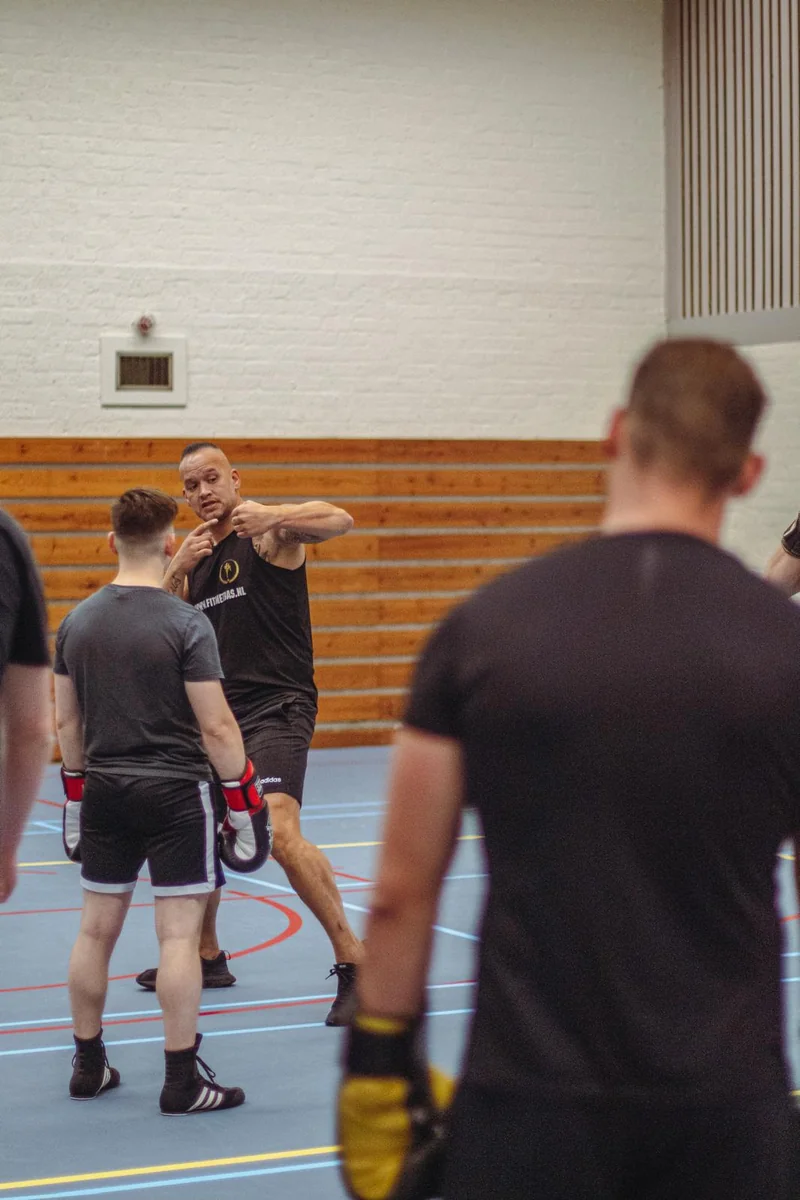Twee deelnemers oefenen stootcombinaties op de pads tijdens een kickboks clinic